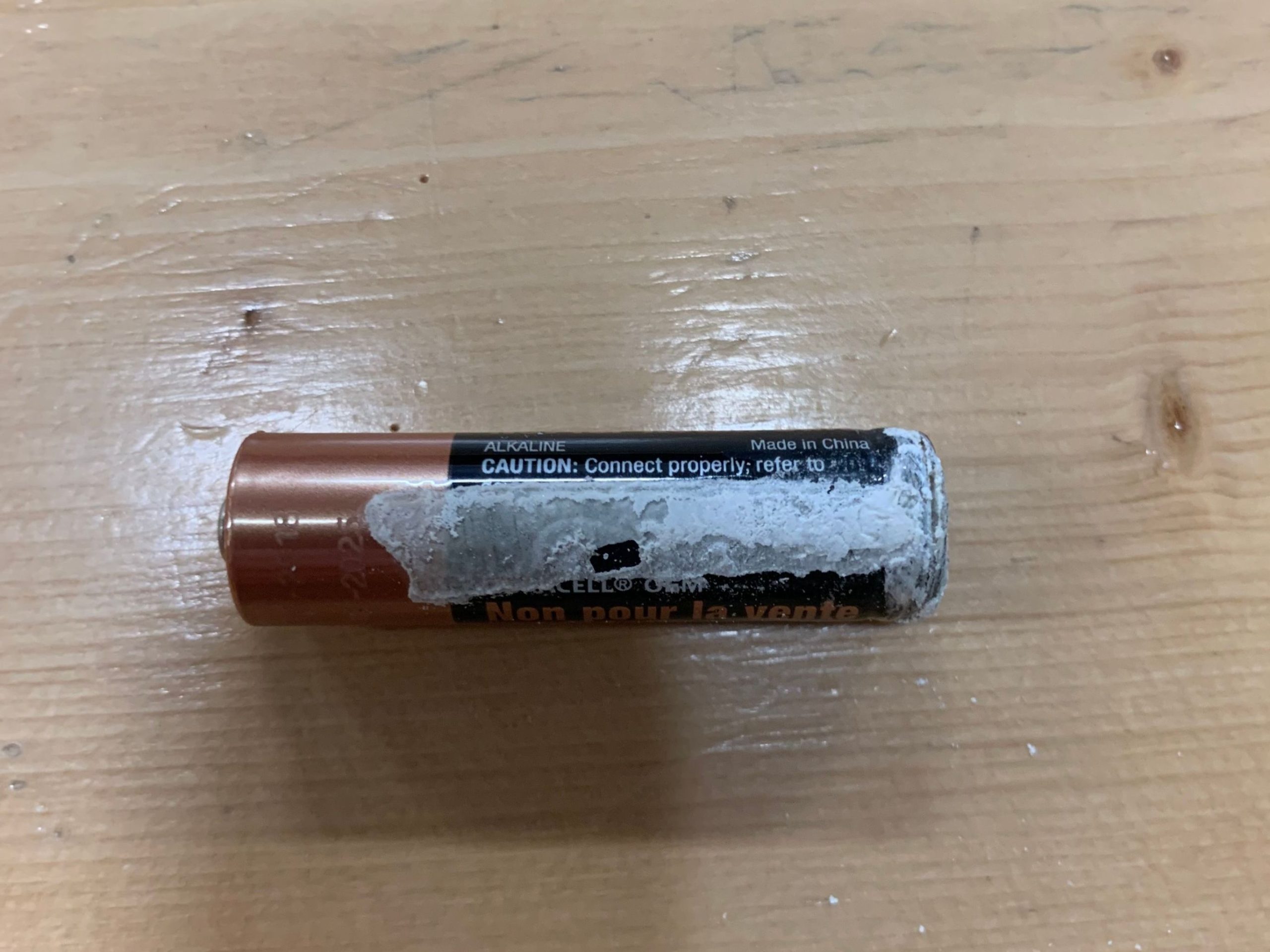 An old AA battery that has leaked.